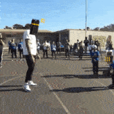 a man with a pencil on his head stands on a basketball court in front of a crowd