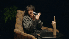 a man sitting in a chair with the word meow written on his face