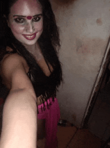a woman is taking a selfie in a dark room .