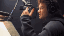 a man wearing headphones is talking into a microphone in a recording studio