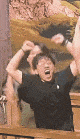 a man wearing glasses and a black shirt is screaming with his mouth open