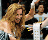 a woman in a boxing ring with a belt that says ' wwe ' on it