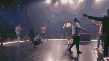 a group of people are dancing on a stage with a man wearing a hoodie that says " i love you " on the front