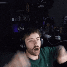 a man wearing headphones and a green shirt with nrg written on it