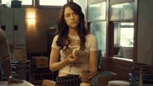a woman in a crop top holding a donut