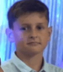 a close up of a young boy 's face with a blue background .