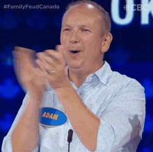 a man with a name tag that says adam applauds