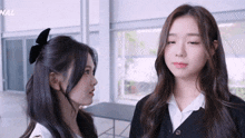 two girls are looking at each other and the word nal is on the bottom left