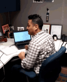 a man sits at a desk with a laptop on it