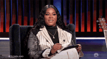 a woman is sitting in a chair with a nbc logo on the bottom right