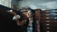 a woman in a white dress is standing in a dark room
