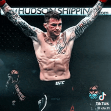 a shirtless ufc fighter stands in front of a hudson shipping sign