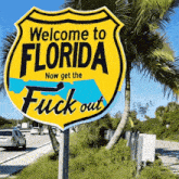 a yellow sign that reads welcome to florida now get the fuck out