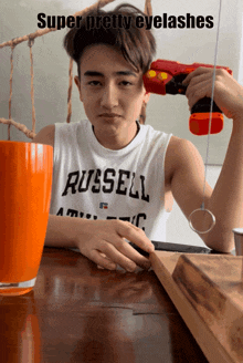 a boy wearing a russell tank top holds a toy gun
