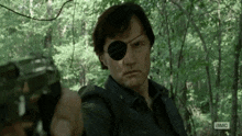 a man with a bandage on his eye is pointing a gun at someone .