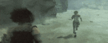 a person in a video game is running in the snow while another person watches .