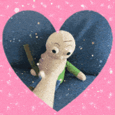 a person holding a stuffed doll in a heart shaped frame