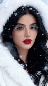 a woman wearing a white fur coat and a hood with snowflakes on her hair is standing in the snow .
