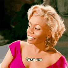a woman in a pink shirt is smiling and says take me .