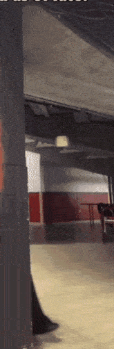 a room with a red and white wall and an exit sign