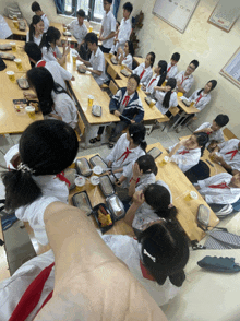 a group of students sit at their desks in a classroom eating food