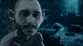 a close up of a man 's face with a blue background
