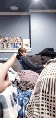 a man sitting on a couch with a sign that says your life