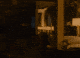 a woman in a white tank top is standing in a dark room with her mouth open