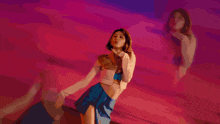 a woman in a green dress is making a heart with her hands
