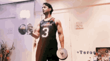 a man wearing a jersey that says bermuda 3 is lifting a dumbbell