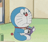 a cartoon character named doraemon is reading a book on the floor