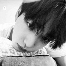 a black and white photo of a boy laying on a blanket