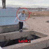 a man in a supreme hoodie is jumping over a hole in a concrete wall