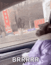 a cat is sitting in the driver 's seat of a car and making a funny face