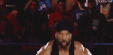 a man in a turban is standing in front of a crowd and screaming .