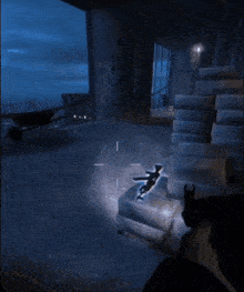 a person is holding a gun in a dark room with a stack of boxes on the floor that say ' concrete '