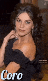 a woman in a black off the shoulder dress with the word coro on the bottom