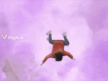 a person is doing a handstand in the air with purple clouds behind them .