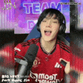a man wearing headphones and a red manchester united shirt