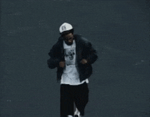 a man wearing a black jacket and a white hat with the number 19 on it