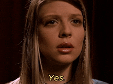 a close up of a woman 's face with the word yes in yellow