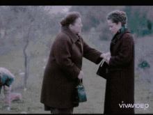 two women are standing next to each other in a field and the words vivavideo are on the bottom
