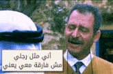a man in a suit and tie is talking to another man with arabic writing above him