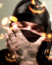 a person covering their face with their hands and pumpkins behind them