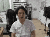 a man in a white scrub is sitting in a chair in a living room .