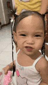 a little girl wearing a hello kitty tank top is smiling