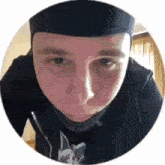 a close up of a man 's face in a circle wearing a hat .