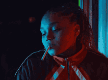 a woman is lighting a cigarette in the dark