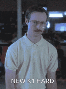 a man with glasses and a mustache is wearing a white shirt that says new k1 hard on it