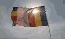 a colorful flag is flying in the wind against a blue sky